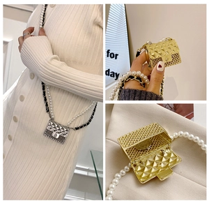 Close-up of mini quilted metal bag with pearl chain strap and round lock in gold and silver