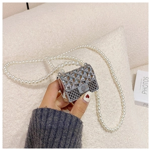 Detail of silver metallic mini bag with quilted flap and elegant pearl shoulder strap