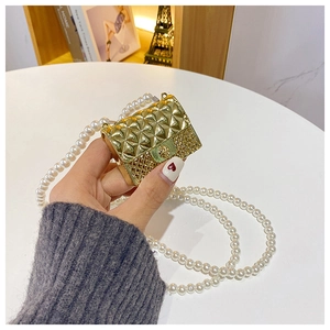 Close-up of golden mini quilted bag with metallic texture and elegant pearl chain strap