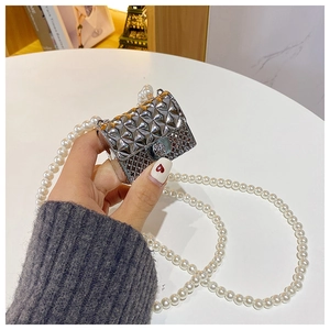 Detail of mini silver quilted bag featuring metallic leopard head clasp and pearl chain