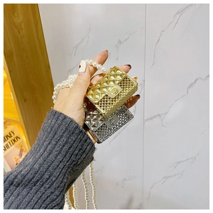 Detail of mini quilted metallic bags in gold and silver with elegant pearl chains