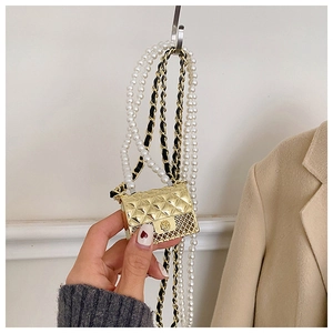 Detail of mini gold quilted crossbody bag with pearl chain and floral clasp ornament