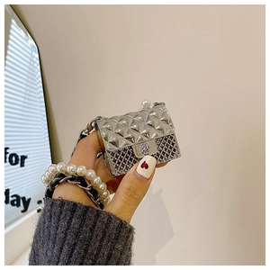Close-up of silver quilted mini bag earphone case with pearl and chain strap