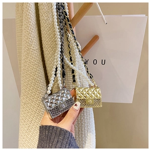 Close-up of mini quilted bags with lion head buckle and decorative pearl chain straps