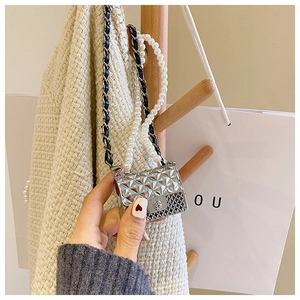 Close-up of silver mini quilted bag with pearl strap and metal chain details