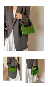 Détail du sac à main en acrylique vert émeraude avec poignée creuse et fini métallique brillant