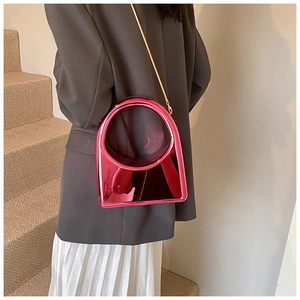 Détail du sac à main en acrylique rose miroir avec grande poignée ronde et chaîne dorée