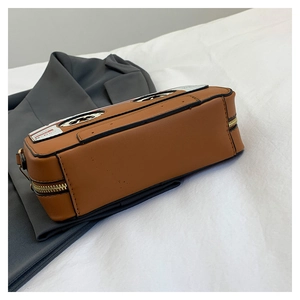 Detail of vintage cassette shape shoulder bag featuring brown leather and gold zipper