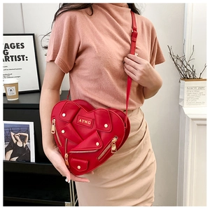 Detail of red heart-shaped biker jacket bag with gold zippers and metal buttons