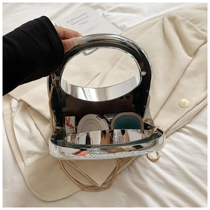 Close-up of silver mirror clutch bag showing spacious interior with chain and handle