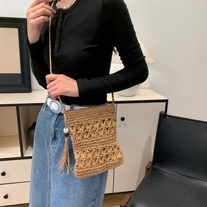 Bohemian woven straw crossbody bag with star cutout patterns and tassel detail