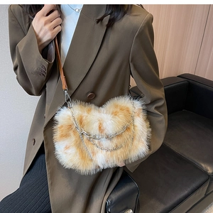 Detail of plush faux fur shoulder bag with silver chains and brown leather strap