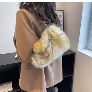 Close-up of fluffy faux fur shoulder bag with decorative silver metal chains and soft texture