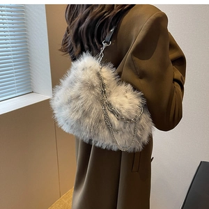 Detail of grey faux fur shoulder bag with silver metal chains on a brown blazer coat