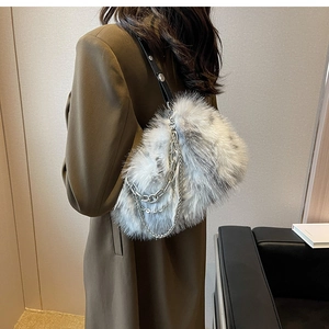 Close-up of a plush faux fur shoulder bag featuring silver chain details and leather strap