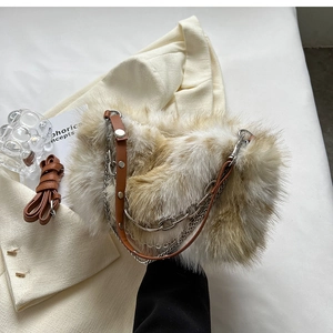 Detail of plush faux fur shoulder bag with leather strap and decorative silver chains