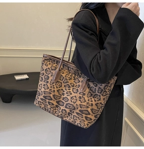 Close-up of leopard print tote bag with brown leather handles for daily commuting