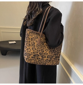 Detail of large leopard print tote bag worn with a black coat for fall fashion