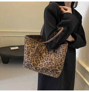 Close-up of leopard print tote bag with brown leather handles and premium stitching