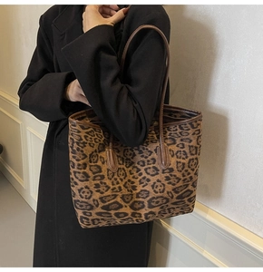 Detail of leopard print tote bag featuring dark brown shoulder straps and textured finish