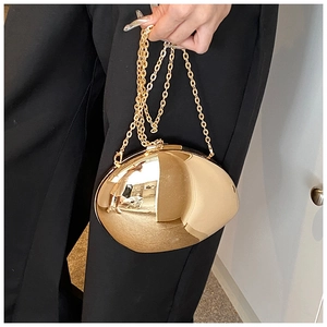 Dettaglio di una pochette a specchio in acrilico dorato con catena per abito da sera