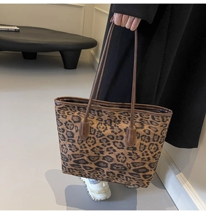 Close-up of leopard print tote bag detailing leather handles and reinforced stitching