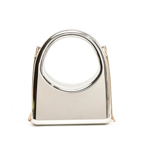 Sleek metallic silver hard shell clutch with large circular handle and gold chain strap