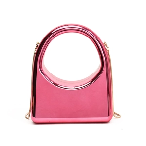 Pink metallic hard shell clutch with large round handle and crossbody chain strap