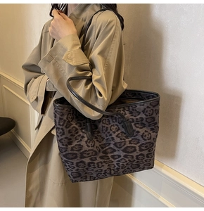 Detailed side view of a large leopard print tote bag styled with a beige trench coat