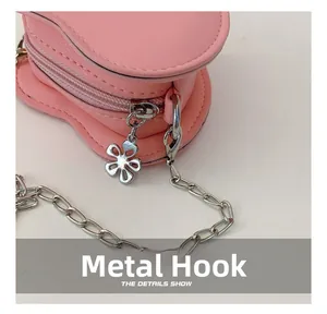 Dettaglio borsa a cuore in pelle rosa con zip a fiore e catena in metallo argentato