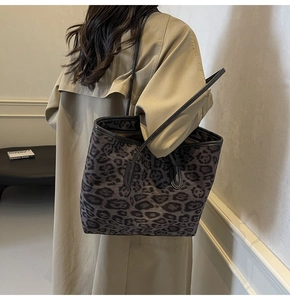 Close-up of a large leopard print tote bag styled with a khaki trench coat for a chic look