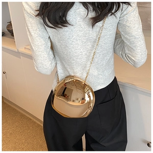 Dettaglio di una borsa a scatola in acrilico a specchio oro liquido con forma sferica irregolare