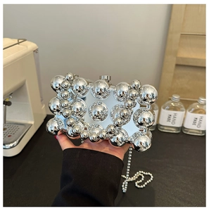 Detailed macro view of the silver metallic beaded surface on the elegant hard shell evening bag