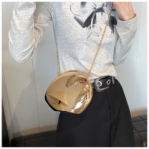 Elegante borsa da sera a specchio dorata con catena indossata da una modella