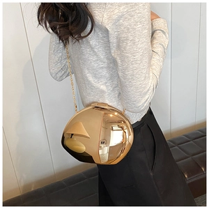 Elegante borsa da sera a sfera dorata con effetto specchio e tracolla a catena su una modella