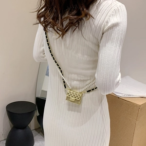 Chic gold mini quilted bag with pearl and chain straps on white knit dress