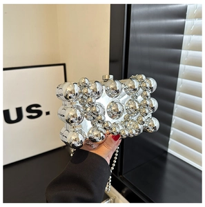 Close-up of a silver spherical dinner bag decorated with polished metal spheres