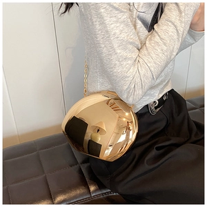 Dettaglio della borsa a sfera in specchio acrilico dorato con elegante tracolla a catena