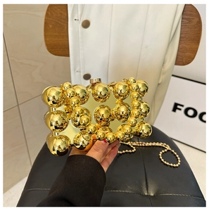 Detail of a gold spherical evening bag featuring glossy metallic bead embellishments