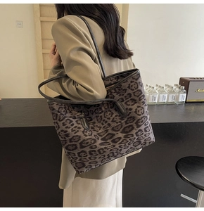 Chic leopard print large tote bag with black leather shoulder straps on a casual model