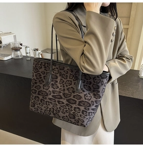 Side view of leopard print tote bag with leather straps on model shoulder