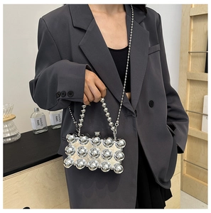 Detail of silver beaded clutch evening bag with metallic finish and removable chain strap