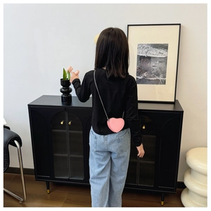 Borsa a tracolla rosa a forma di cuore per bambini con catena argento indossata da bimba