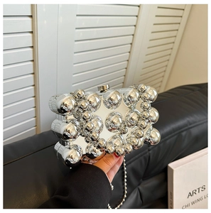 Macro shot of silver egg-shaped clutch with 3D bubble texture and metallic chain