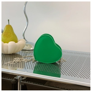 Dettaglio della borsa a cuore verde per bambini con tracolla a catena in metallo argento