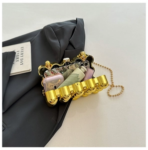 Detail of gold waved evening clutch showing capacity for phone and makeup on a black blazer