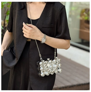 Detail of silver metallic sphere texture and beaded chain on a stylish clutch bag