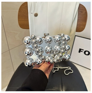 Detailed view of silver evening bag with polished metallic spheres and ball chain