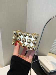 Detailansicht der Mini-Gold-Clutch mit Kugelstruktur und goldener Schlangenkette