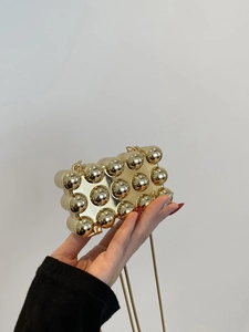 Detailansicht der goldenen Acryl-Miniclutch mit 3D-Kugelstruktur und eleganter Schlangenkette